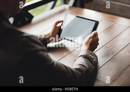 Young man or student using tablet computer in cafe Stock Photo
