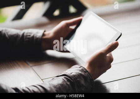 checking email on touchpad, close up of hands using digital tablet in cafe Stock Photo