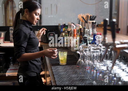 Female bartender mixing a cocktail. Stock Photo