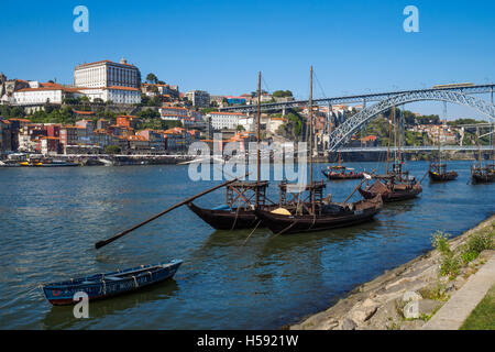 Old style wooden boats (Rabelos) moored on the river Douro by Cais de Gaia overlooking the historic part of Porto, Ribeira and t Stock Photo