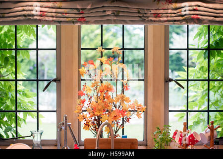 An arrangement of Acer branches and leaves on a cottage kitchen window Stock Photo