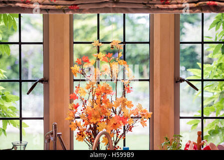 An arrangement of Acer branches and leaves on a cottage kitchen window Stock Photo