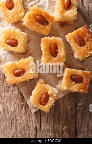 Freshly baked cake with almonds basbousa on paper. vertical top view Stock Photo