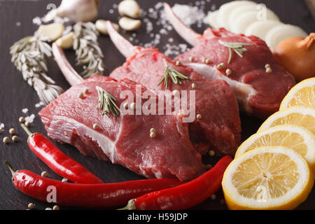 Raw beef steak with spices on a black stone table closeup. horizontal Stock Photo