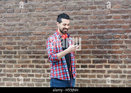 Casual young latin man using a smartphone. Stock Photo