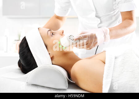 Ultrasonic massager Light skin treatment, the woman in the beauty salon Stock Photo