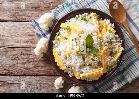 Paleo Food: Cauliflower rice with scrambled eggs and herbs on a plate. horizontal view from above Stock Photo