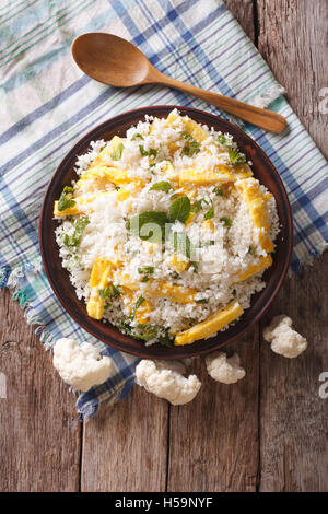 Paleo Food: Cauliflower rice with scrambled eggs and herbs on a plate. vertical view from above Stock Photo