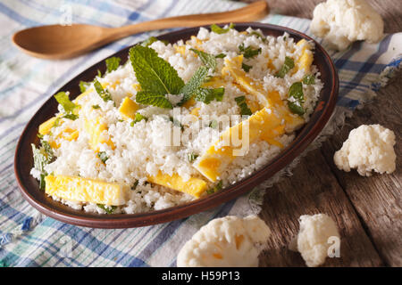 Cauliflower rice with scrambled eggs and mint for paleo close-up on a plate. horizontal Stock Photo