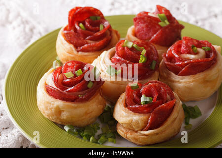 baked roll with salami and cheese in the form of roses close-up on a plate. horizontal Stock Photo