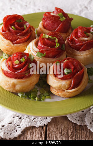 Beautiful food: roll with salami and cheese on a plate close-up. Vertical Stock Photo