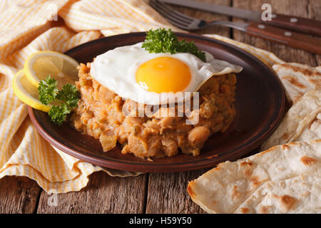 Arabic ful medames with a fried egg and bread close-up on the table. horizontal Stock Photo