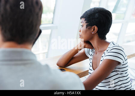 Two young colleagues having coffee break together at cafe Stock Photo