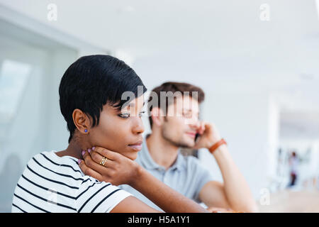 Two young colleagues having coffee break together at cafe Stock Photo