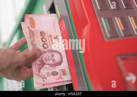 Closeup of woman's hand withdrawing cash from ATM Stock Photo