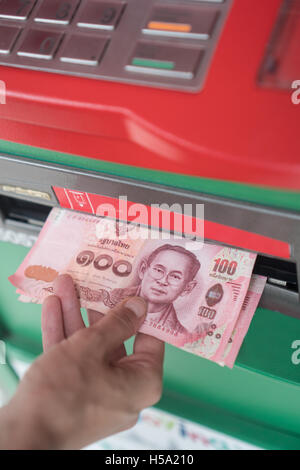 Closeup of woman's hand withdrawing cash from ATM Stock Photo