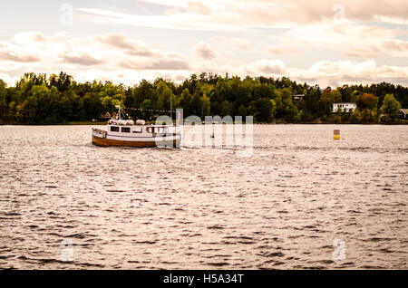 wooden boat floating on norwegian fjord in autumn Stock Photo