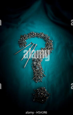 Small Twin-fast Screws lined in shape of Question Mark on dark background Stock Photo