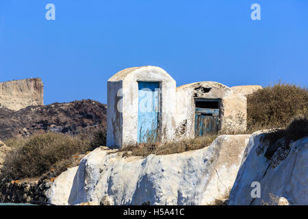 Dilapidated buildings with rotting doors and peeling blue paintwork in Manolas village on the island of Thirassia, Santorini Stock Photo