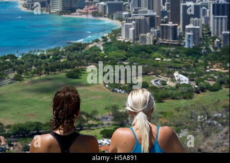 Two female tourists enjoying the view of Waikiki tourist area of Honolulu from Diamond Head mountain Stock Photo