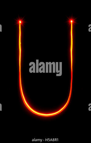 red thin light painting letter U on black background Stock Photo