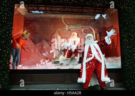 Father Christmas stands outside and admires the Christmas window displays themed as 'Shine on', at Sefridges department store in Oxford Street in central London. Stock Photo