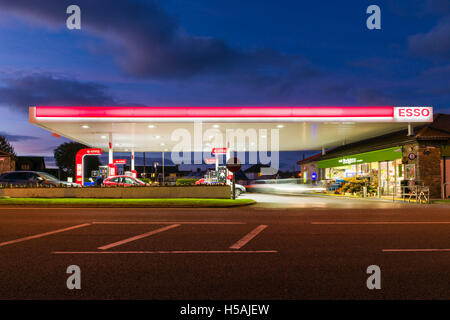 A filling station forecourt lit up at dusk. Stock Photo