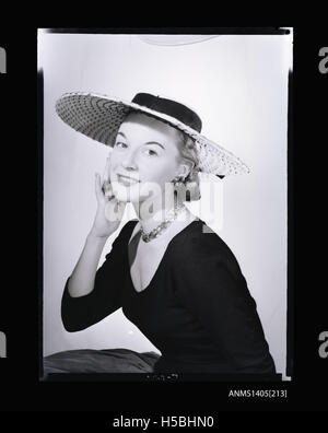 A 1954 photograph of a woman modeling streetwear, showcasing fashion trends from the mid-20th century. The image captures the style and clothing choices of the era, with street fashion emerging as a cultural influence during this period. Stock Photo
