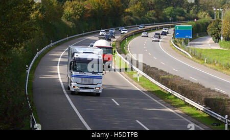 Trucks rolling in highway traffic from above and with blank road direction signs Stock Photo