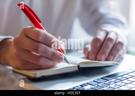 Businessman taking notes with laptop background Stock Photo