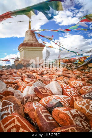 Mani stones ( Marnyi Stones with OM MANI PADME HUM -  six syllabled mantra of Tibetan Buddhism engraved on them ) Stock Photo