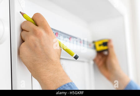Man installing cassette roller blinds on windows. Stock Photo