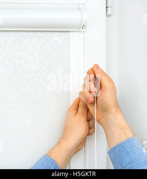 Man installing cassette roller blinds on windows. Stock Photo