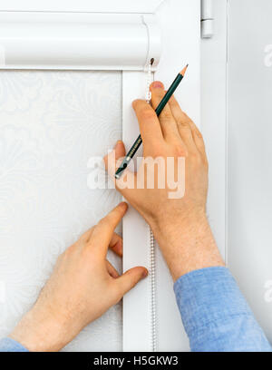Man installing cassette roller blinds on windows. Stock Photo