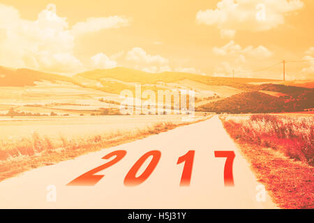 new year 2017 written on rural road countryside photoshop warm filter applied Stock Photo