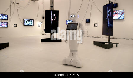 London-based artist Cecile B. Evans' 'Sprung a Leak 2016', a multi-dimensional work featuring two humanoid robots and a robot dog who communicate with human performers present in the space via monitors, held at Tate Liverpool from Friday October 21 - Sunday March 19. Stock Photo
