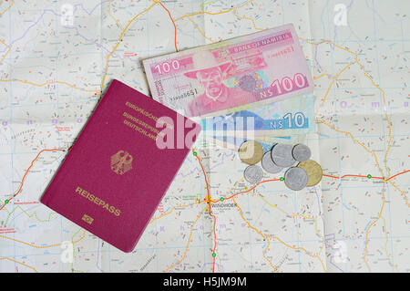 German Passport and Namibia Dollars and coins on map of Namibia Stock Photo