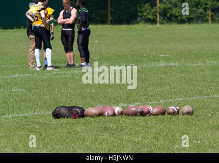 A line of American footballs on training field Stock Photo