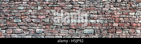 Stone wall panorama, panoramic stonewall pattern background, old aged weathered red and grey grunge limestone dolomite slate Stock Photo