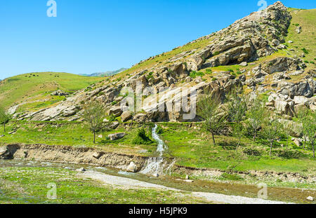 The mountain stream flowss down to the river in valley between Zarafshan and Gissar mountain ranges of Pamir-Alay, Uzbekistan. Stock Photo