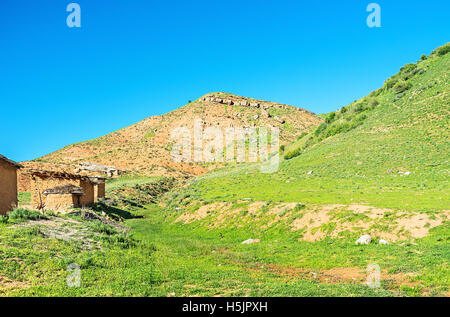 The red mountain and small earthen houses in Zarmas village, Uzbekistan. Stock Photo