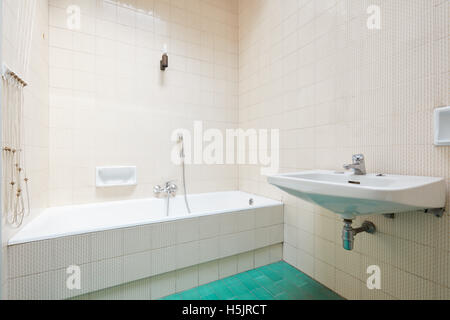 Old bathroom, tiled interior with bathtub Stock Photo