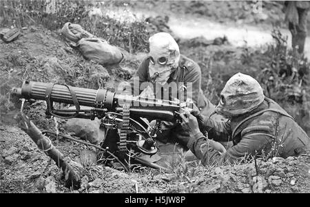 MACHINE GUN CORPS First World War. Two man gun crew (loader and firer) wearing early PH-type gas helmets using a Vickers Mk 1 water-cooled machine gun  in a dugout near Ovillers in July 1916 during the Battle of the Somme. Stock Photo