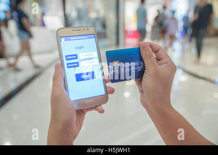 Woman verified account balance on smartphone with mobile banking application and credit card. Online shopping. Stock Photo