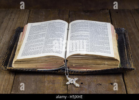Old Holy Bible on rustic wood table with cross book mark Stock Photo