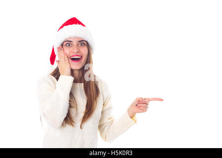 Woman in red christmas hat pointing on something Stock Photo