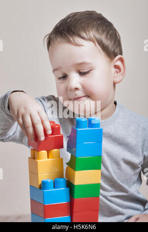 Playing little boy with colored cubes Stock Photo