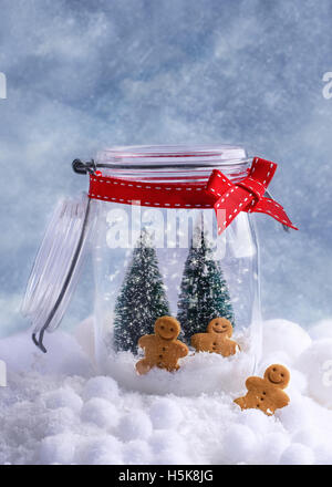 Small gingerbread biscuits in glass cookie jar for Christmas Stock Photo