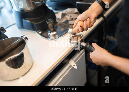 Barista tampering coffee before preparing it Stock Photo