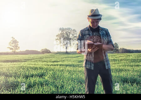 man in nature with backpack and read book Stock Photo